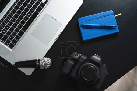 Foto de Ordenador portátil, cámara, micrófono y portátil en el escritorio de un periodista - Imagen libre de derechos
