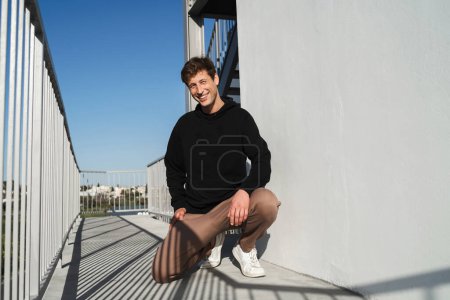Foto de Retrato de un joven adulto en la calle con espacio en blanco en su sudadera con capucha negra - Imagen libre de derechos