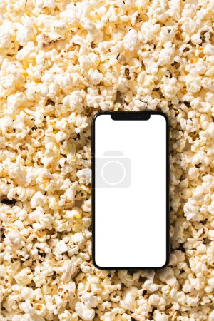 Téléchargez les photos : Délicieux pop-corn et smartphone avec écran vierge pour votre design. - en image libre de droit
