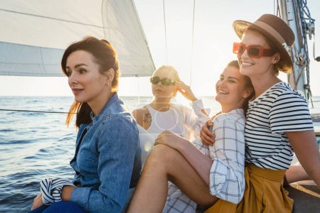 Foto de Chicas felices amigos de vacaciones relajarse en el velero durante la navegación en el mar. - Imagen libre de derechos