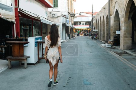 Téléchargez les photos : Une jeune femme adulte marche dans les rues de Chypre pendant les vacances d'été - en image libre de droit