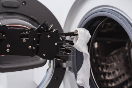 Foto de Primer plano de la mano del robot real y la lavadora. Concepto de desarrollo de inteligencia artificial y automatización robótica de procesos. - Imagen libre de derechos