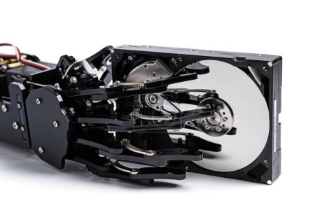 Foto de Mano robótica real con unidad de disco duro. Conceptos de protección de datos impulsada por IA o aprendizaje automático. - Imagen libre de derechos