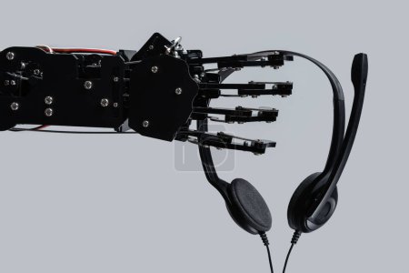 Foto de Mano de robot real con auriculares. Concepto de inteligencia artificial y el uso de Chatbots en los negocios en línea. - Imagen libre de derechos
