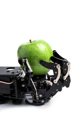 Téléchargez les photos : Gros plan de la main du vrai robot avec de la pomme verte. Concept de développement de l'intelligence artificielle et automatisation des processus robotisés. - en image libre de droit
