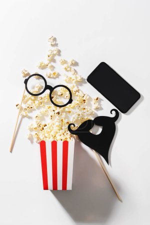 Photo for Delicious popcorn, party props and smartphone with blank screen for your design. - Royalty Free Image