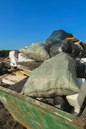 Foto de Contenedor lleno de residuos de construcción y escombros en un sitio de construcción. - Imagen libre de derechos