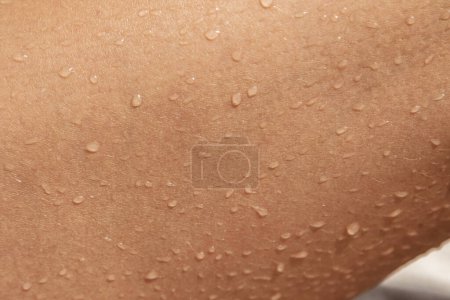 Téléchargez les photos : Texture rapprochée de la peau féminine bronzée humide - en image libre de droit