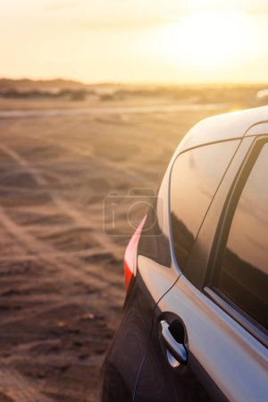 Téléchargez les photos : Beau coucher de soleil et moderne Car Off-roading près de la plage. - en image libre de droit