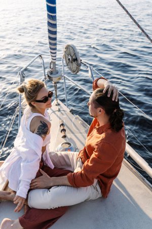 Téléchargez les photos : Jeune couple séduisant se détendre sur le voilier pendant la voile dans la mer. - en image libre de droit
