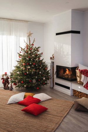 Téléchargez les photos : Intérieur d'un salon moderne avec cheminée, orné d'un sapin de Noël et décorations festives. - en image libre de droit