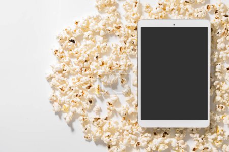 Téléchargez les photos : Dispersé délicieux pop-corn et tablette avec écran vierge pour votre conception - en image libre de droit
