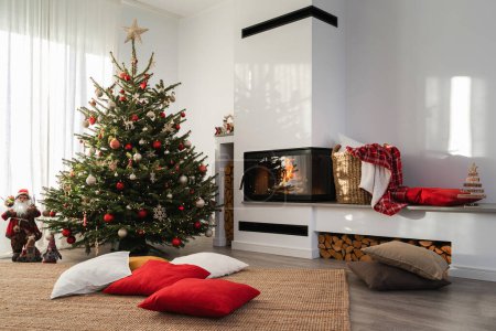 Photo for Interior of a modern living room with a burning fireplace, adorned with a Christmas tree and festive decorations. - Royalty Free Image