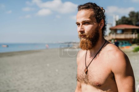 Foto de Retrato de hombre barbudo guapo con torso desnudo en la playa - Imagen libre de derechos