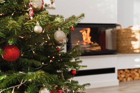 Foto de Primer plano del árbol de Navidad en la moderna sala de estar con chimenea. - Imagen libre de derechos