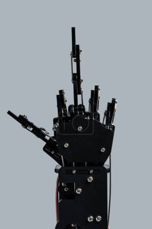 Téléchargez les photos : Véritable main robotique donnant le majeur sur fond gris. Concepts de la prise de contrôle de l'IA et singularité technologique. - en image libre de droit