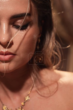 Téléchargez les photos : Portrait de femme magnifique avec effet cheveux mouillés, fards à paupières dorés et eye-liner précis. - en image libre de droit