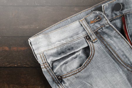 Photo for Closeup of unbuttoned jeans on wooden background - Royalty Free Image