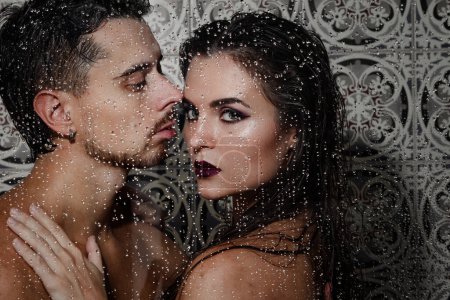 Photo for Portrait of beautiful and sensual couple captured through wet glass - Royalty Free Image