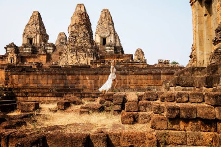 Foto de Hermosa joven vestida con túnica blanca en antiguas ruinas Khmer, Angkor Wat - Imagen libre de derechos