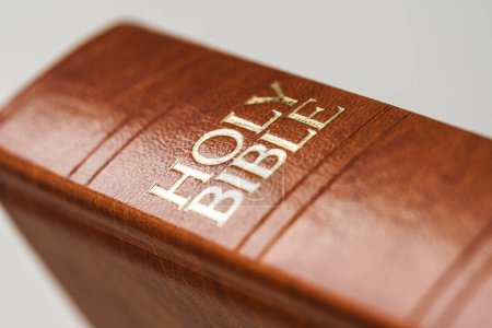 Photo for A macro shot of a leather cover holy bible book with white background focused on the spine of the book - Royalty Free Image