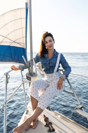 Téléchargez les photos : Portrait de femme séduisante se relaxant sur voilier lors de la voile en mer - en image libre de droit