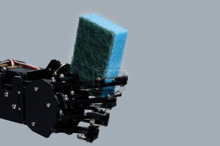 Foto de Esponja de mano de robot real para lavavajillas sobre fondo gris. - Imagen libre de derechos