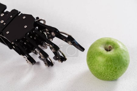 Photo for Closeup of real robot's hand with green apple. Concept of Artificial intelligence development and robotic process automation. - Royalty Free Image