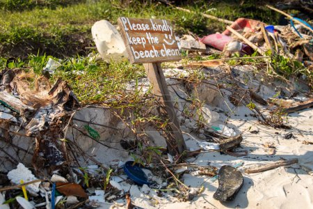 Téléchargez les photos : Panneau disant "'S'il vous plaît veuillez garder la plage propre" "et pile de différents plastiques et déchets autour - en image libre de droit