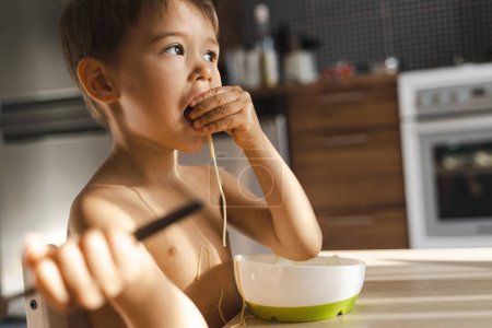 Foto de Niño lindo comiendo su comida favorita - Spaghetti. - Imagen libre de derechos