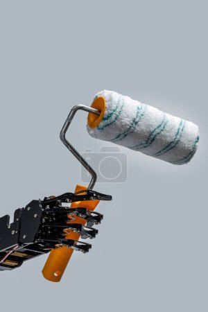 Foto de Mano robótica real con rodillo de pintura. Conceptos de desarrollo de inteligencia artificial o sustitución de puestos de trabajo por IA. - Imagen libre de derechos