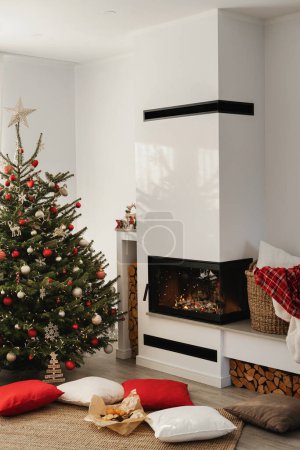 Foto de Interior de una moderna sala de estar con chimenea, adornada con un árbol de Navidad y decoraciones festivas. - Imagen libre de derechos