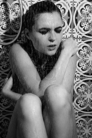 Photo for Monochrome portrait of sad and wet woman with smudged makeup on her face under the shower - Royalty Free Image