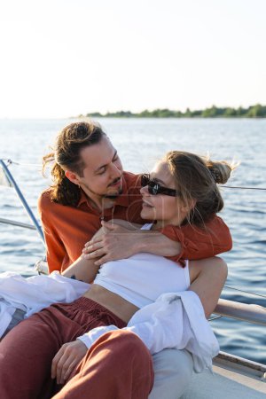 Foto de Joven pareja atractiva relajarse en el velero durante la navegación en el mar. - Imagen libre de derechos