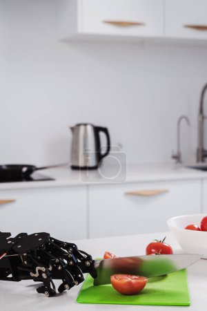 Foto de Robot real corte a mano tomates frescos con cuchillo afilado. Concepto de automatización robótica de procesos. - Imagen libre de derechos