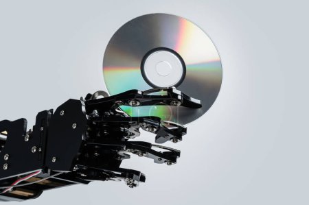 Photo for Real robotic hand with compact disc. Concepts of AI development and data storage. - Royalty Free Image