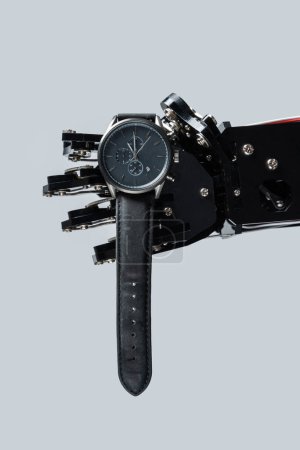 Téléchargez les photos : Véritable main robotique avec montre-bracelet. Concepts de gestion du temps ou rapidité du développement de l'IA. - en image libre de droit