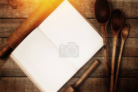 Téléchargez les photos : Divers ustensiles de cuisine en bois et livre de cuisine vintage sur la table. - en image libre de droit