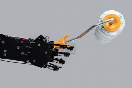 Foto de Mano robótica real con rodillo de pintura. Conceptos de desarrollo de inteligencia artificial o sustitución de puestos de trabajo por IA. - Imagen libre de derechos