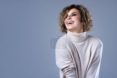 Téléchargez les photos : Portrait studio d'une jeune femme élégante portant un pull à col roulé. - en image libre de droit