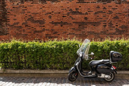 Téléchargez les photos : Scooter moteur moderne avec un design vintage sur la vieille rue de la ville - en image libre de droit