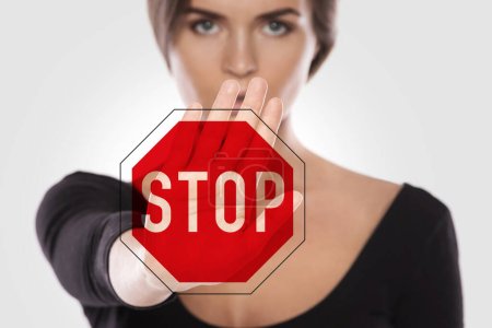 Photo for Angry woman and stop sign. Women's rights - stop discrimination, harassment and violence against women. - Royalty Free Image