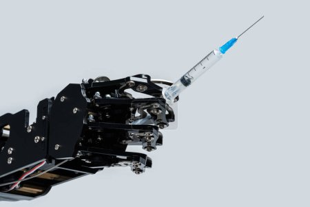 Téléchargez les photos : Véritable main robotique avec seringue. Concept d'intelligence artificielle et robots en médecine. - en image libre de droit