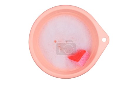 Washing clothes in a pink basin. Detergent with washcloths. Top view. Isolate on a white background.