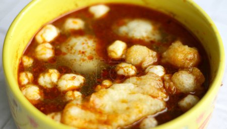 Baso Aci with spicy sauce. Baso aci is made from tapioca flour mixed with seasoning and served with tofu, pilus, lime, and fried bakso or meatballs. Indonesian street food.