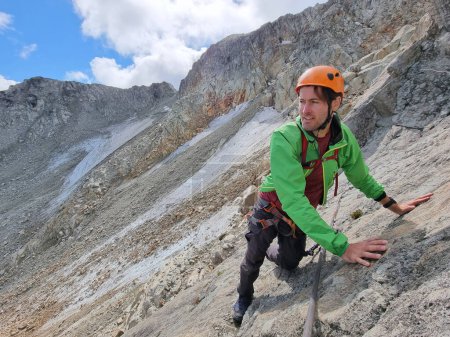 Via Ferrata mountain hike climber man climbing on steep rock in Whistler, BC, Canada travel destination. Summer adventure.