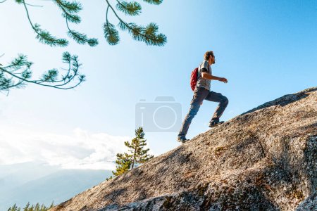 Défis, succès et réalisations dans les affaires et la vie. Image conceptuelle aspirationnelle de l'homme de randonnée homme en forme escalade et randonnée montagne escarpée en montée.
