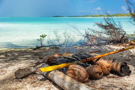 Pescado polinesio barbacoa tradicional francesa Polinesia comida en la playa - excursión de actividad turística luau en Fakarava, Tahití, Polinesia Francesa. Pescado a la parrilla sobre carbón de coco y madera de palmera.