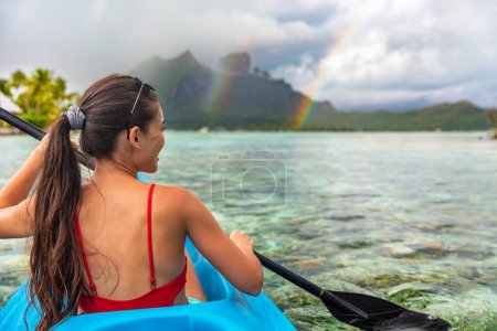 Kayak femme activité nautique touriste profitant du kayak à Bora Bora au mont Otemanu, Tahiti, Polynésie française. Mode de vie sportif océanique actif.
