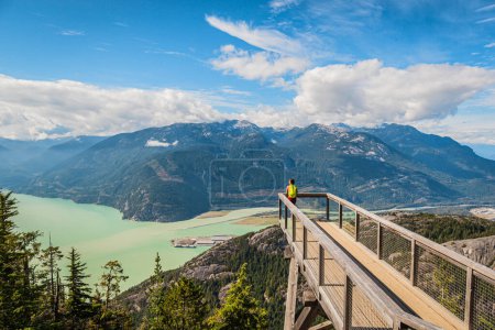 Squamish, British Columbia nature with hiking woman hiker in looking at view of amazing landscape on viewing platform on famous Sea to Summit hike in BC. Popular outdoor activity destination, Canada